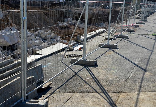 a temporary construction site fence panel with orange safety mesh